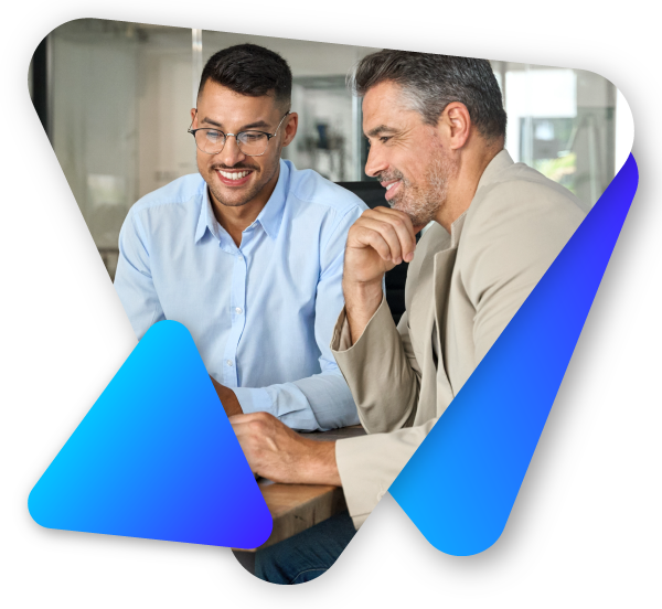 Two men smiling and looking at a laptop screen in a bright office.